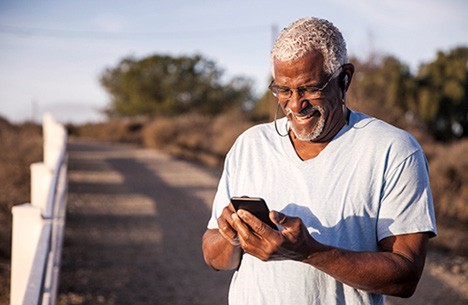 Man looks at phone and smiles. 