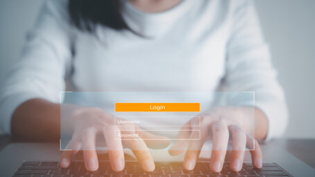 Woman types on keyboard with a glowing yellow search box appearing in front of her.