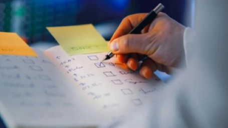 Close up of someone checking off a box on a checklist